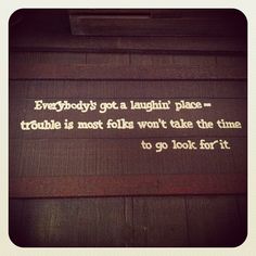 a sign that is on the side of a building saying everybody's got a laughter place - trouble is most folks won't take the time to go look for it