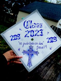 someone holding up a graduation cap that says class 2012 and has a cross on it