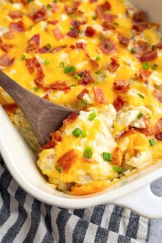 a casserole dish with bacon, cheese and green onions