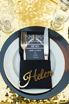 the table is set with gold sequins and black napkins that say hello