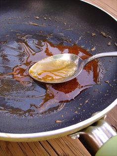 a spoon with some food on it in a pan filled with water and sauces