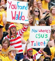 a group of people holding up signs in front of a crowd that say you fand walo now where's csu's talent?