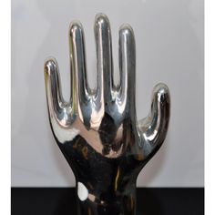 a silver hand sculpture sitting on top of a black table