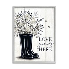 a black boot with white flowers in it and the words love grows here written below