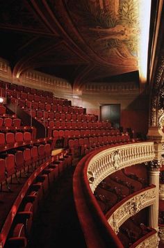 an empty auditorium with red seats and ornate railings