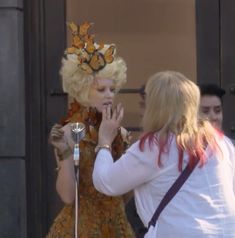 two women standing next to each other in front of a building with butterflies on their head