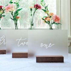 three vases with flowers in them sitting on a table