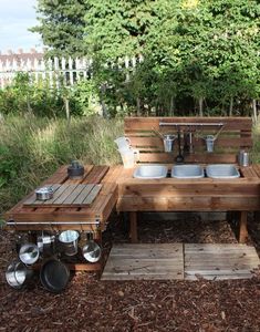 an outdoor kitchen made out of wooden pallets and steel pans, with pots and pans on them