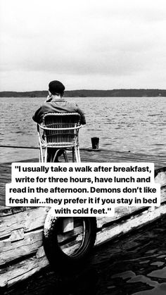 a man sitting on top of a boat next to the ocean with a quote about life