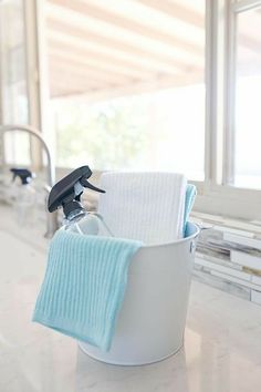 a white bucket filled with towels next to a window