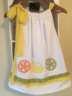 Lemonade Summer Party Dress with a lovely gingham yellow fabric bow on adjustable neckline, appliquéd lemons , limes and oranges on front and back. Green and yellow country ruffle just above hem. So cute for a lemonade theme birthday party or even your local summer lemonade stand This dress is a One of a kind and very versatile. Length of dress from gathered neckline to hem is 21 1/2 inches long. Armhole area is 5 inches long and of course the gingham yellow bow sets on shoulder. Full width at h Playful White Dress For Picnic, Cotton Lemon Print Dress For Garden Party, Yellow Cotton Dress For Picnic, Green Lemon Print Dress For Garden Party, Cute Yellow Dress For Picnic, Summer Lemonade, Lemonade Party, Yellow Gingham, Yellow Bow