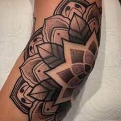 a tattoo on the arm of a man with an intricate design in black and grey