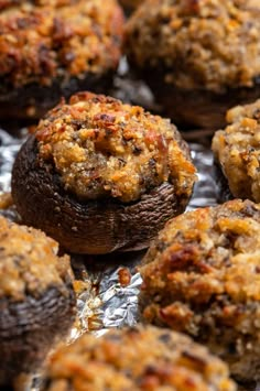 several baked goods sitting on top of tin foil covered in sauce and toppings, ready to be eaten