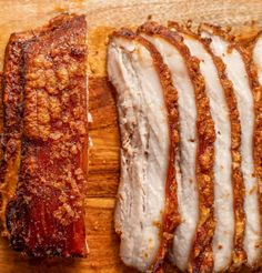 sliced pork on a cutting board with sauce and seasoning