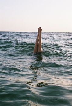 a person is floating in the water with their feet above the water's surface