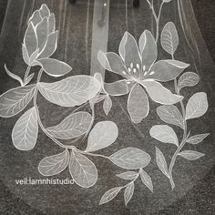 a clear veil with white flowers and leaves on it