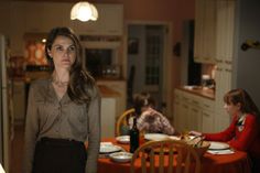 a woman standing in front of a kitchen table