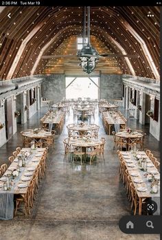 the inside of a barn with tables and chairs set up for an outdoor wedding reception