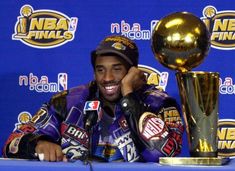 a man sitting at a table next to a trophy