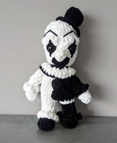 a crocheted panda bear with black and white clothes