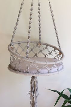 a macrame style hanging basket with tassels and beads on the bottom