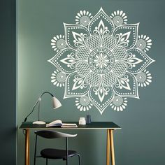 an intricate wall decal in the shape of a flower on a green wall next to a desk