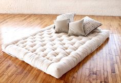 a futon bed with four pillows on top of it