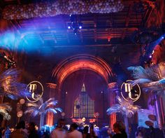 a group of people standing in front of a building with lights and decorations on the ceiling