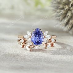 a tan gold ring with a blue sapphire surrounded by white diamonds