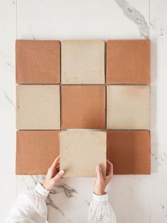 a person is placing tiles on the wall