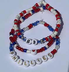 Acknowledge your love for the Phillies and MV3 Bryce Harper with this bracelet set. The size and player number can be personalized!  Please read our policies below before purchasing and don't hesitate to contact us with any questions you may have.  Go Phils! *BEAD TYPE: Glass Beads on Elastic .7mm Cord *PROCESSING TIME: Our current processing time is 4-6 business days.  Processing is the time needed to prepare your order for shipment and is NOT the amount of time it will take your order to be delivered to you. *SHIPPING: Orders are shipped via USPS first class with tracking.  WE ARE NOT RESPONSIBLE FOR USPS DELAYS OR LOST/DAMAGED PACKAGES.  We do not issue refunds for these circumstances.  Should any of these situations occur, a claim needs to be placed by the buyer. *CARE INSTRUCTIONS: Do Red Beaded Name Bracelet With Round Beads, Personalized Red Wristband With Round Beads, Adjustable Red Name Bracelet With Round Beads, Red Beaded Name Bracelet, Red White And Blue Bracelets, Red And Blue Bracelets, Phillies Bracelet, Houston Astros Bracelet, Patriotic Red Beaded Bracelet With Round Beads