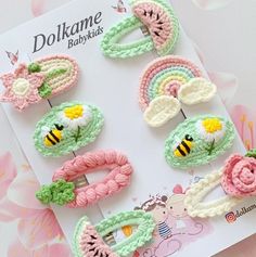 crocheted hair clips with flowers and bee on them are laying next to a card