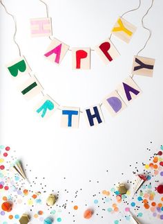 a birthday banner with the words happy birthday spelled in colorful letters and confetti