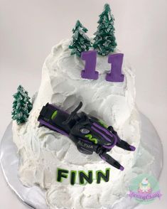 a cake decorated with white frosting and purple decorations