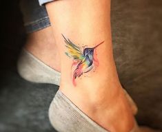 a small tattoo on the ankle of a woman's foot with a hummingbird