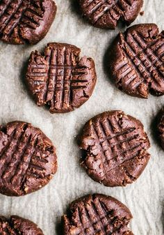 chocolate cookies are arranged on a piece of parchment paper