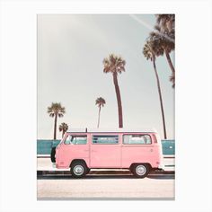 an old pink van parked in front of palm trees