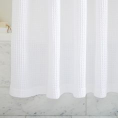 a white shower curtain in a bathroom