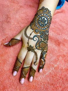 a woman's hand with henna tattoos on it