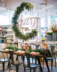 a table with chairs and flowers on it in front of a sign that says cheezy