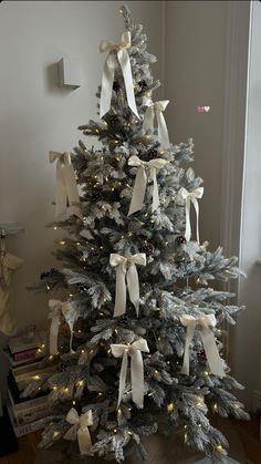 a white christmas tree with bows and lights