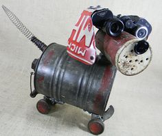 a dog made out of an old barrel with a sign on it's head