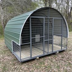 a large green metal shelter with two dogs in it's doors and one dog inside