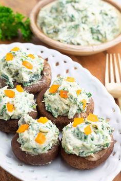 baked potatoes topped with cream cheese and carrots on a white plate