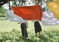 two women are holding flags in their hands while standing under the shade of a tree