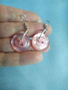 Handmade button dangle earrings to dress up your clothes attire for any dress occasion or everyday wear.  The buttons  are a shiny pinkish rose color,  attached to a jump ring, Earrings with ear wire closure,  Earrings for pierced ears, Gift for mom, gift for sister. Pink Nickel-free Clip-on Earrings As Gift, Elegant Handmade Pink Clip-on Earrings, Pink Nickel-free Drop Clip-on Earrings, Nickel Free Pink Drop Clip-on Earrings, Nickel-free Pink Drop Clip-on Earrings, Pink Round Clip-on Earrings For Gift, Handmade Pink Clip-on Earrings For Gift, Jump Ring Earrings, Pink Drop Earrings