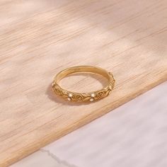 a gold ring with pearls on it sitting on a wooden surface