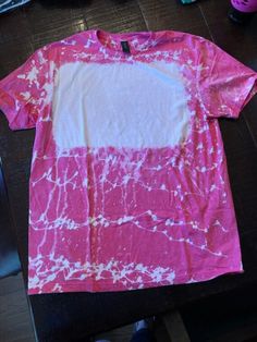 a pink and white shirt sitting on top of a wooden table