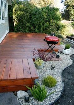 a wooden deck surrounded by plants and potted plants