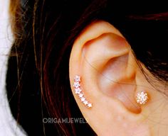 a close up of a person's ear with two piercings on it and one behind the ear